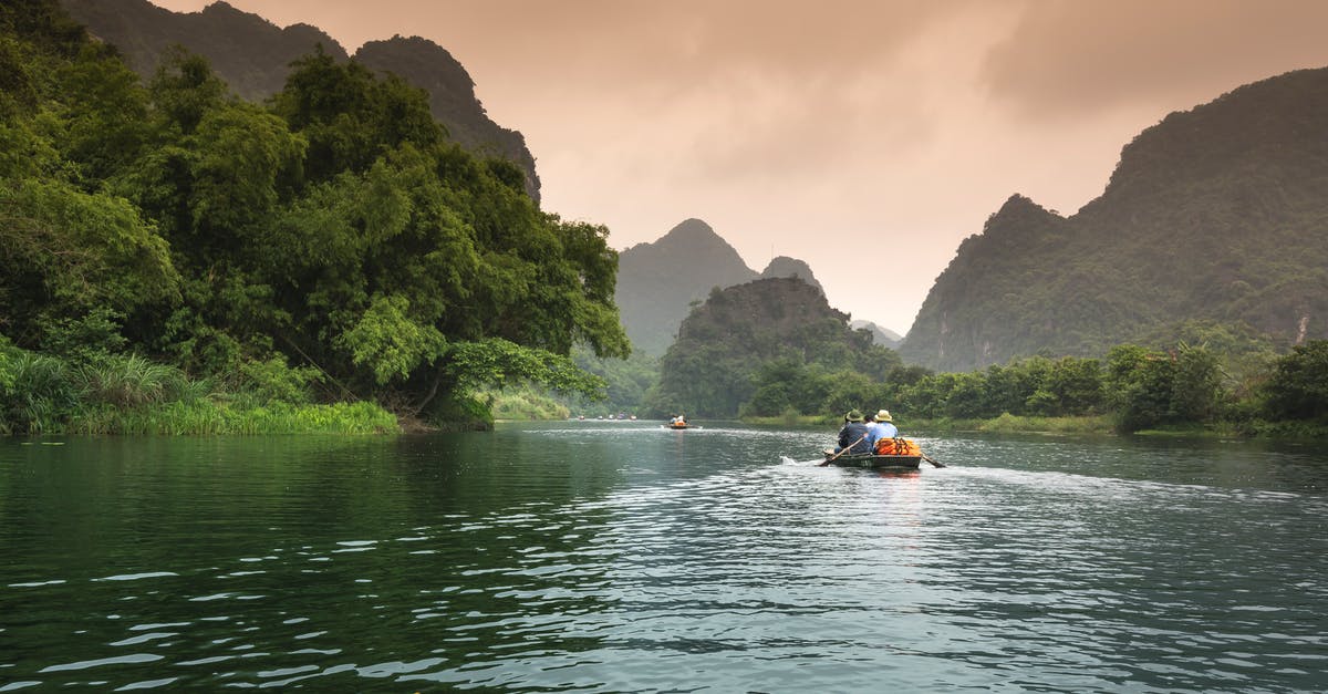 A small boat in a body of water with Yulong River in the background
