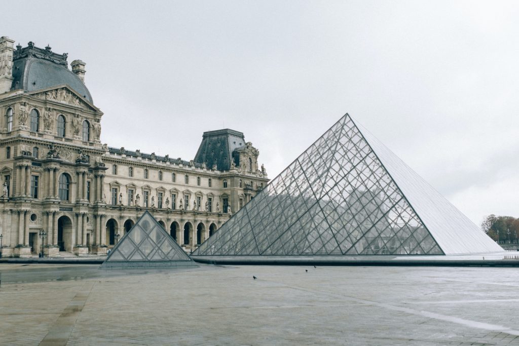 A large bridge over some water with Louvre in the background
